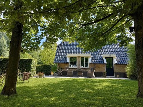 Vooraanzicht met terras onder de bomen
